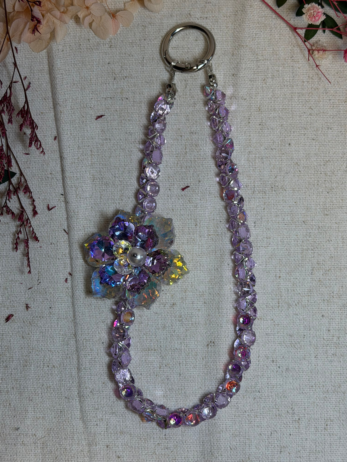 Bijou de téléphone “Éclat Lilas” – Fleur cristal & perles scintillantes